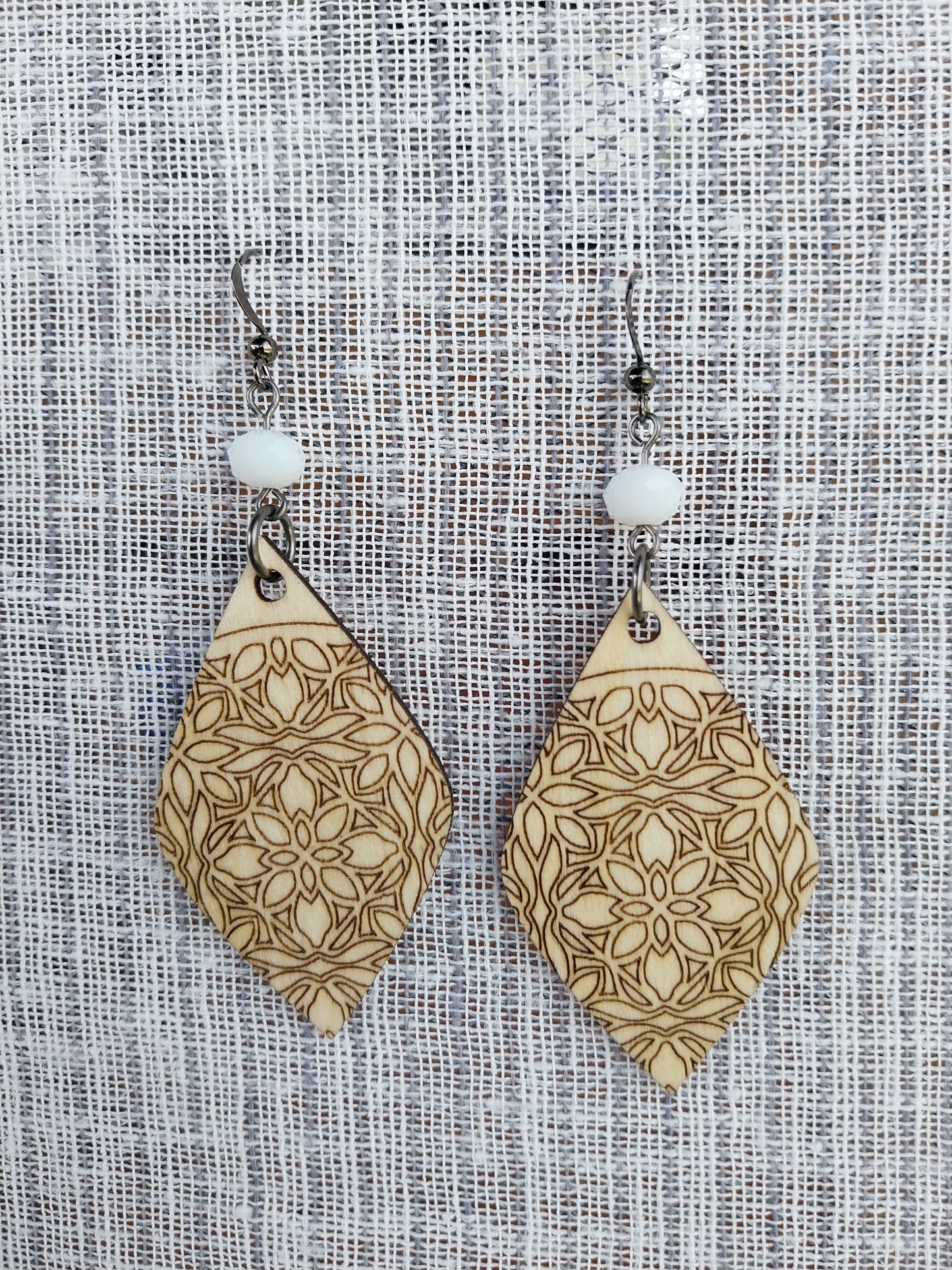 Boucles d'oreille dentelle de bois gravé et perles à facettes blanc laiteux.