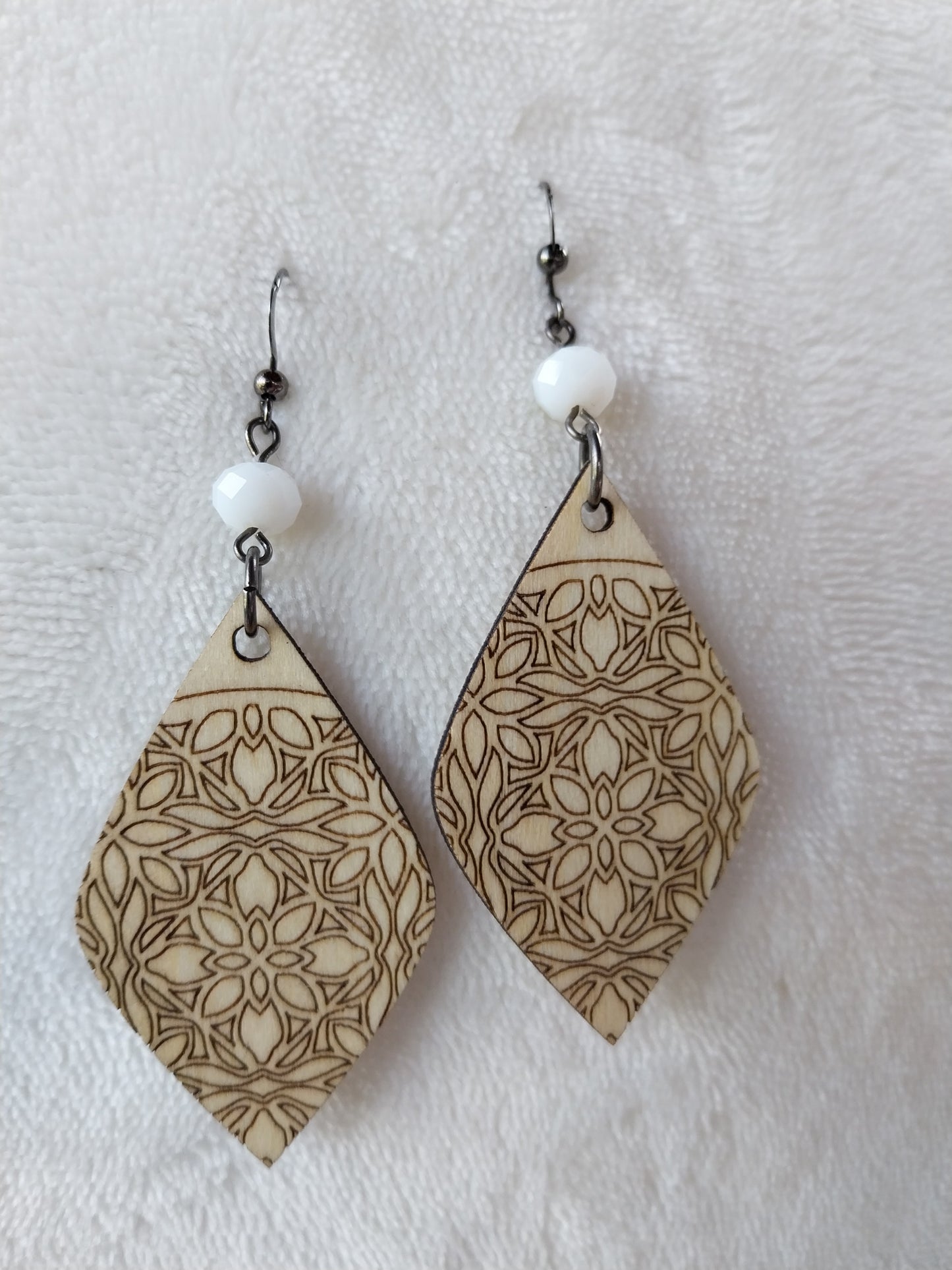 Boucles d'oreille dentelle de bois gravé et perles à facettes blanc laiteux.
