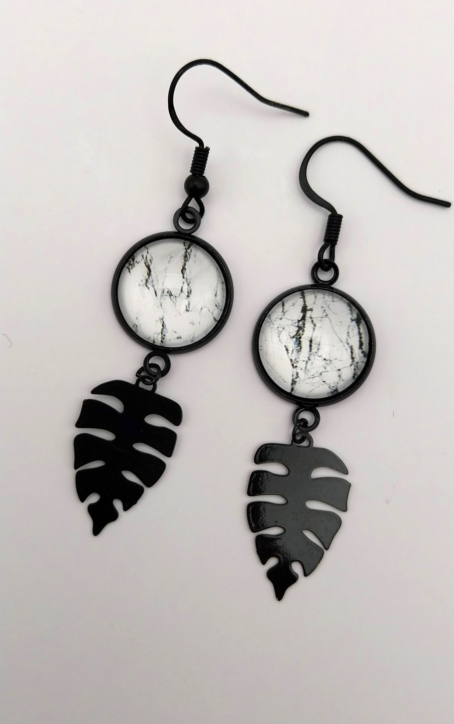 Boucles d'oreille cabochon marbré noir et blanc et breloque feuille tropicale