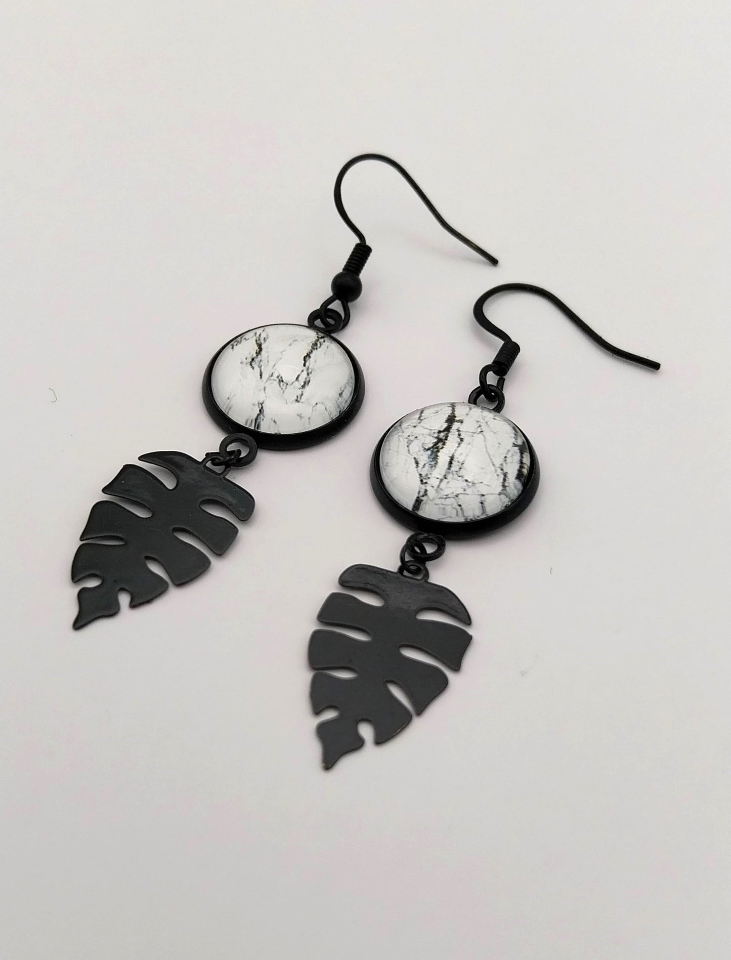Boucles d'oreille cabochon marbré noir et blanc et breloque feuille tropicale
