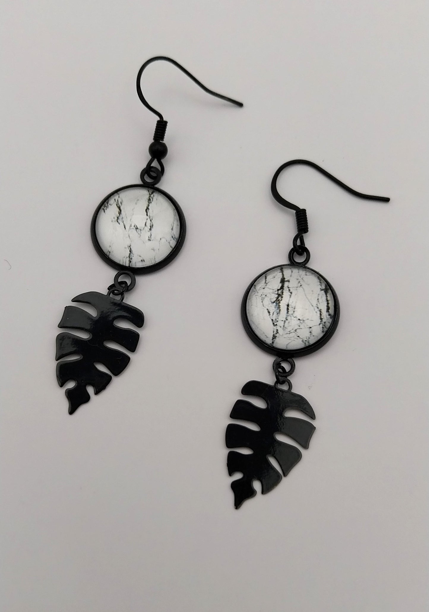 Boucles d'oreille cabochon marbré noir et blanc et breloque feuille tropicale