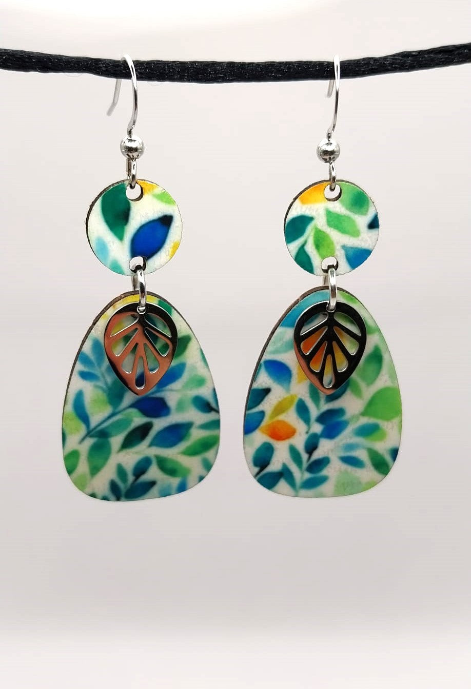 Boucles d'oreille en bois multicolore avec breloques feuille.