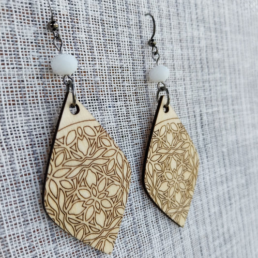 Boucles d'oreille dentelle de bois gravé et perles à facettes blanc laiteux.