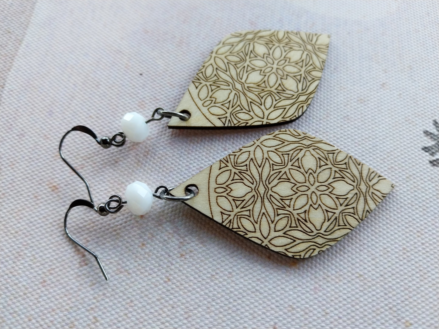 Boucles d'oreille dentelle de bois gravé et perles à facettes blanc laiteux.